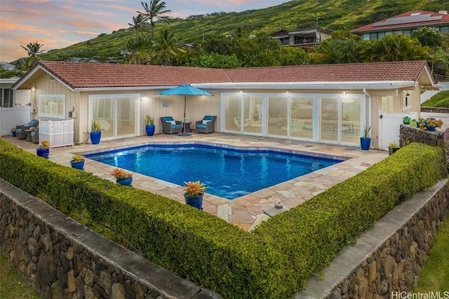 pool at dusk featuring a patio area