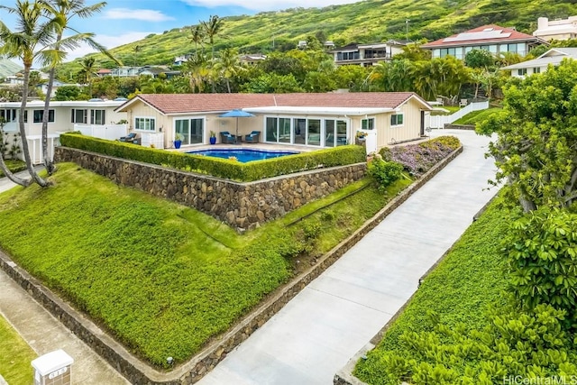 rear view of property featuring a fenced in pool