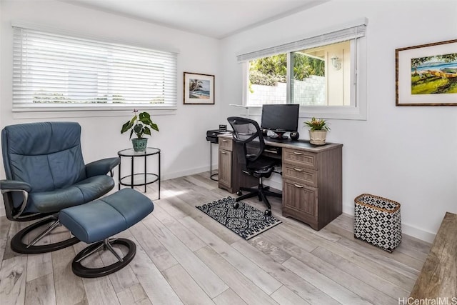 home office with light hardwood / wood-style floors