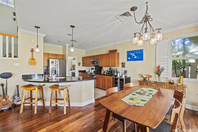 dining room with dark wood-type flooring, ornamental molding, and sink