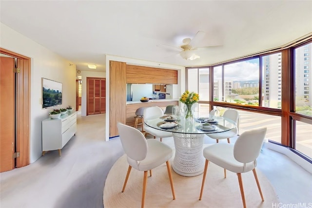 dining space featuring ceiling fan and a wall of windows