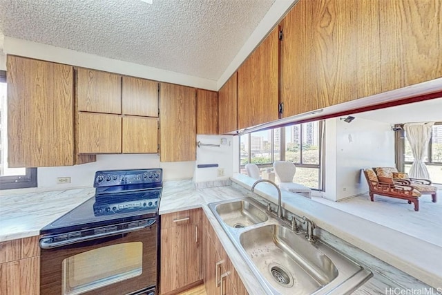 kitchen with black electric range oven, sink, a textured ceiling, and a wealth of natural light