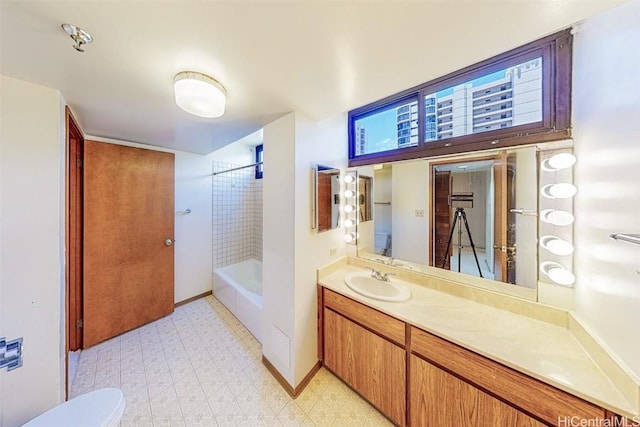 full bathroom with vanity, toilet, and tiled shower / bath combo