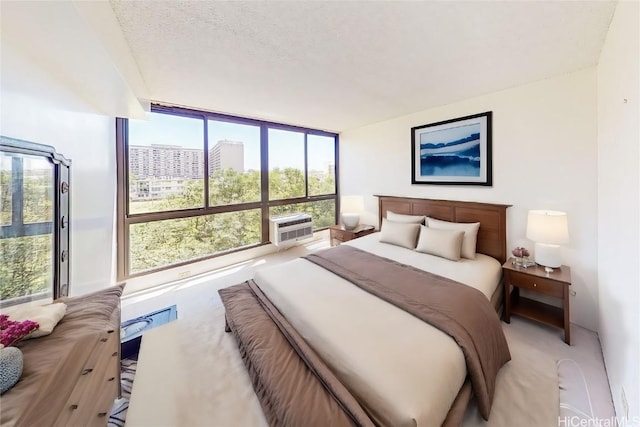 carpeted bedroom featuring floor to ceiling windows and a textured ceiling