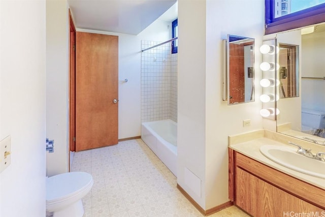 full bathroom featuring vanity, tiled shower / bath, and toilet