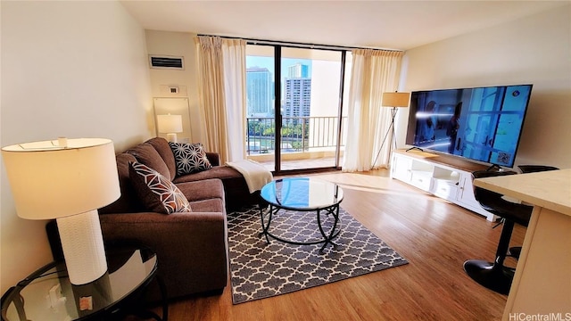 living room with a wall of windows and hardwood / wood-style floors