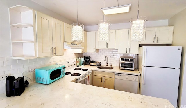 kitchen with decorative backsplash, sink, pendant lighting, and white appliances