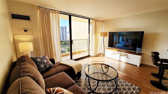 living room featuring expansive windows, visible vents, and wood finished floors