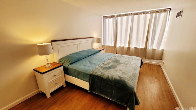 bedroom featuring baseboards, visible vents, and dark wood-type flooring