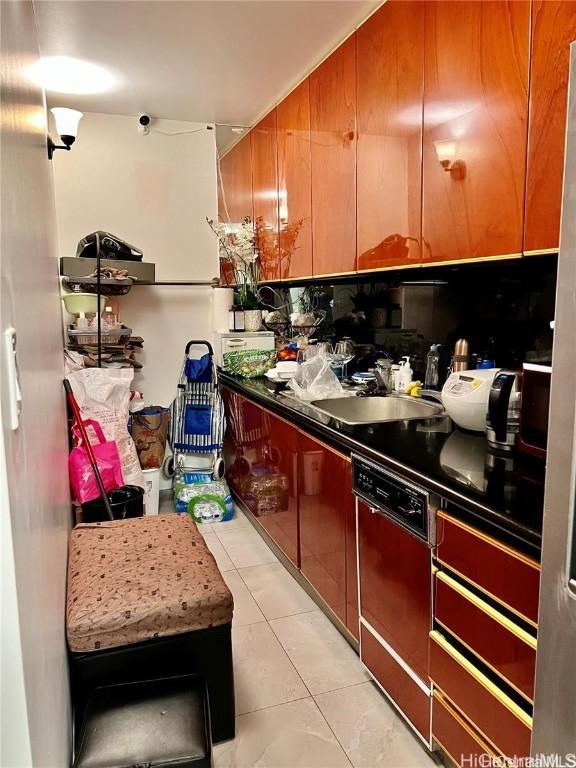 kitchen featuring light tile patterned floors, sink, and dishwashing machine