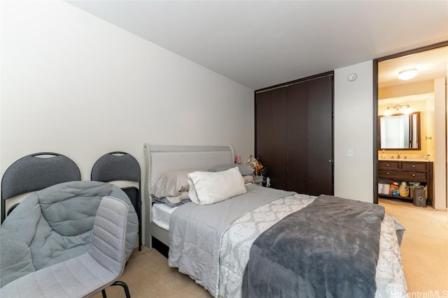 bedroom featuring ensuite bath and light carpet