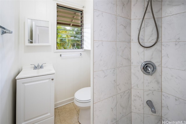 bathroom with toilet, a tile shower, and vanity