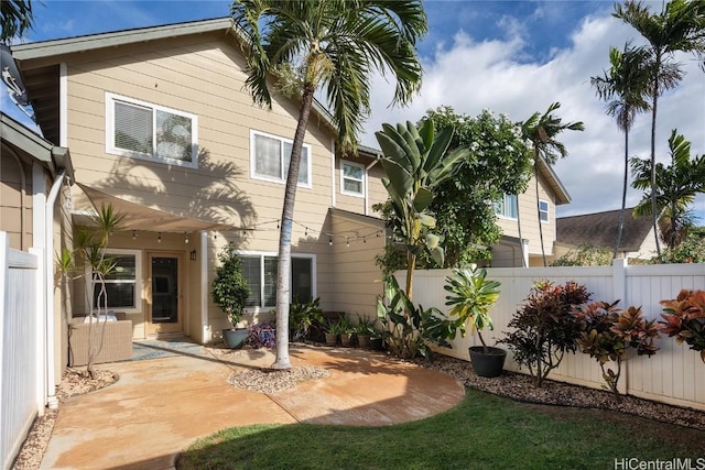 rear view of house with a patio area and fence