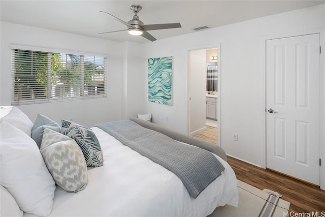 bedroom with ceiling fan, hardwood / wood-style floors, and ensuite bath