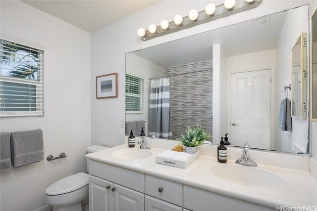 bathroom with toilet, vanity, and a shower with shower curtain