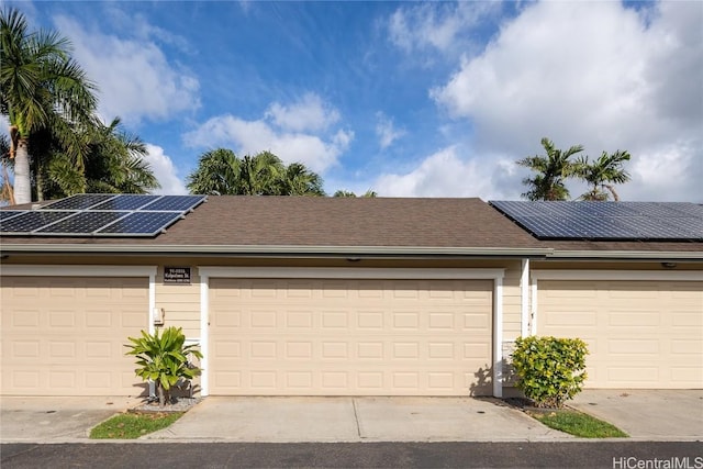 view of front of property featuring a garage and solar panels