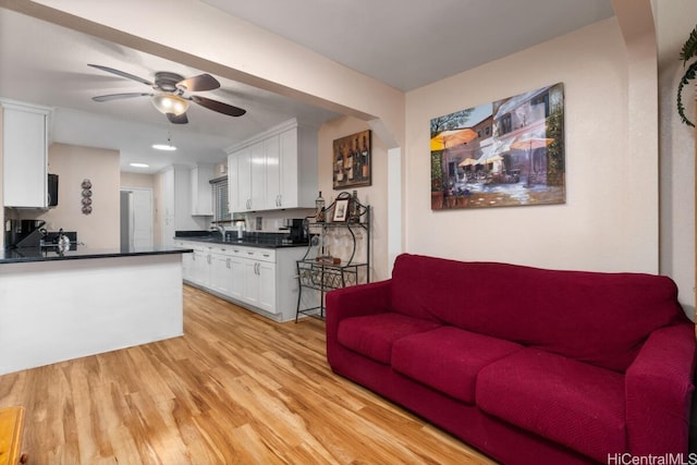 living room featuring ceiling fan and light wood-type flooring