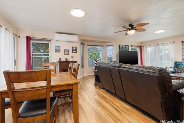 living room featuring light hardwood / wood-style floors, plenty of natural light, and a wall mounted AC