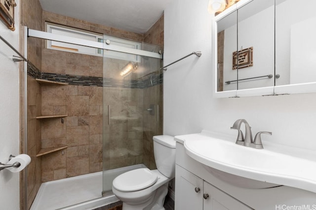 bathroom with toilet, a shower with shower door, and vanity