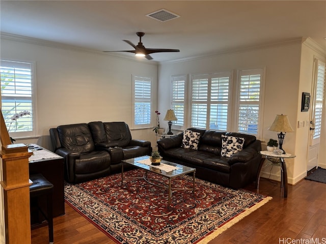 living room with ornamental molding, visible vents, ceiling fan, and dark wood-type flooring