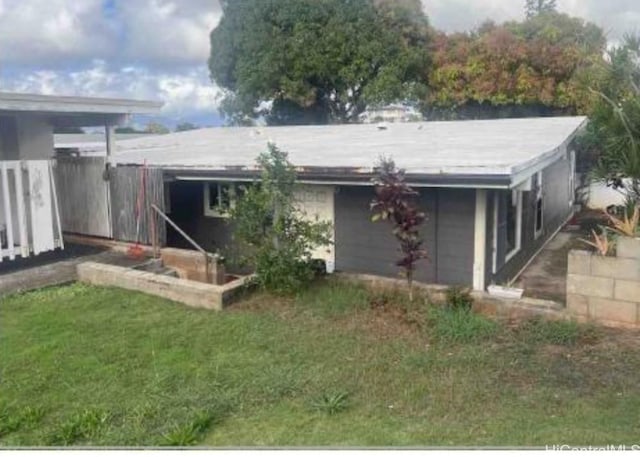 rear view of house featuring a lawn