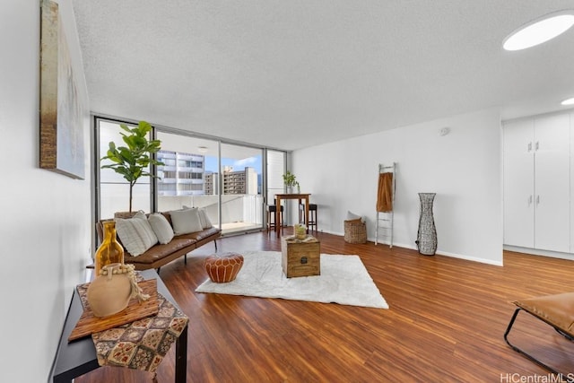 living room with hardwood / wood-style floors, expansive windows, and a textured ceiling