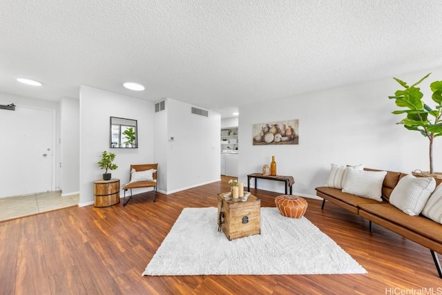 living room with hardwood / wood-style flooring and a textured ceiling