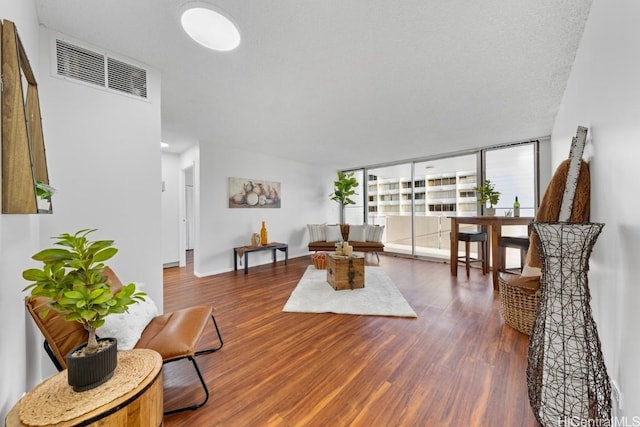 living room featuring a wall of windows and dark hardwood / wood-style floors