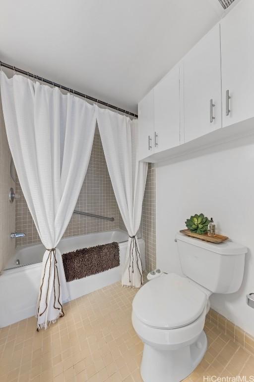 bathroom featuring tile patterned floors, toilet, and shower / bath combo