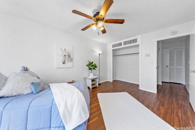 bedroom with a closet, ceiling fan, a textured ceiling, and dark hardwood / wood-style flooring