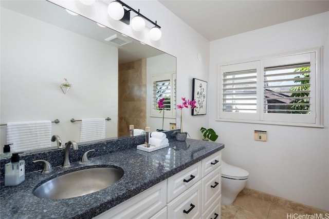 bathroom featuring vanity, tile patterned floors, and toilet