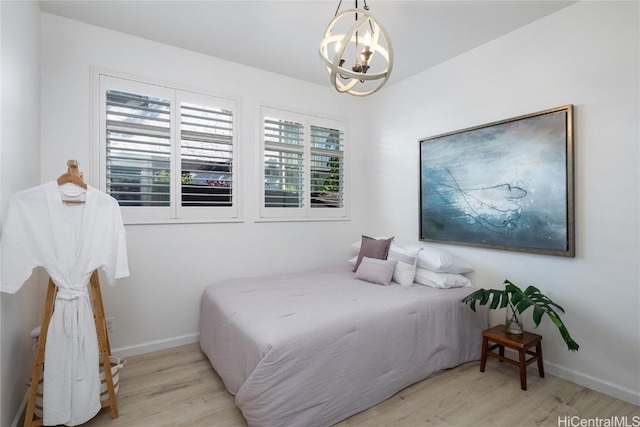 bedroom featuring a notable chandelier and light wood-type flooring