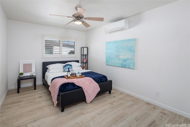 bedroom with ceiling fan, a wall mounted air conditioner, and light hardwood / wood-style floors