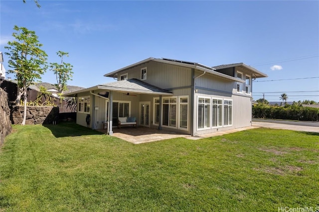 rear view of house with a patio and a lawn