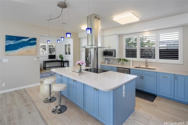 kitchen featuring pendant lighting, sink, appliances with stainless steel finishes, island exhaust hood, and a kitchen island