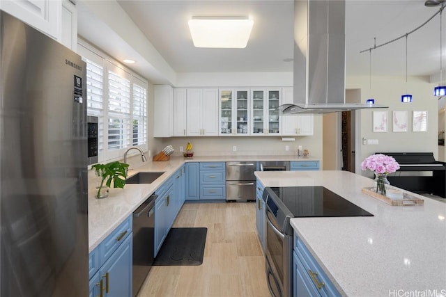 kitchen featuring pendant lighting, appliances with stainless steel finishes, island exhaust hood, white cabinets, and blue cabinets