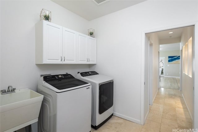 clothes washing area featuring cabinets, sink, and washing machine and dryer