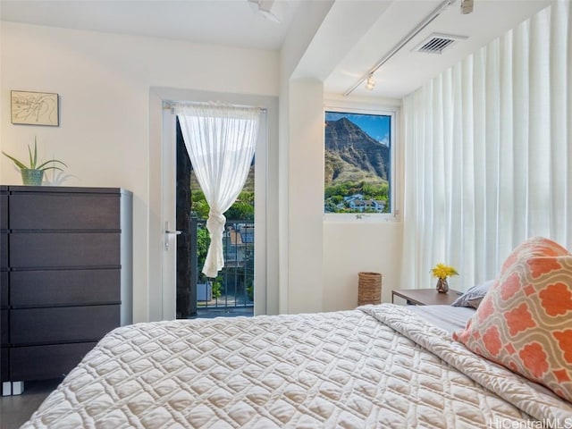 bedroom featuring track lighting and access to outside