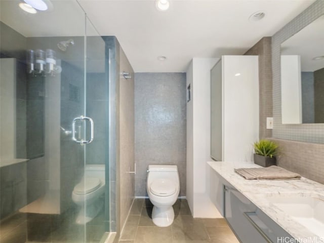 bathroom with toilet, vanity, an enclosed shower, and tile patterned flooring