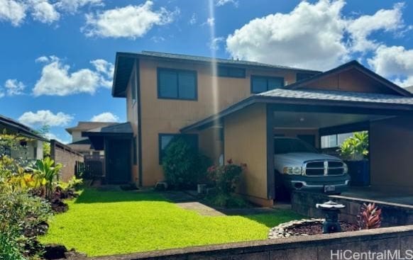 back of property featuring a carport and a yard