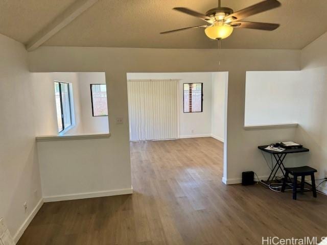 unfurnished room with ceiling fan, hardwood / wood-style flooring, and lofted ceiling with beams