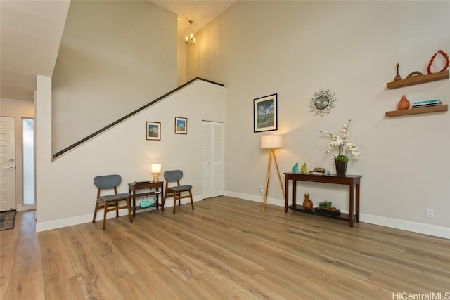 sitting room with a towering ceiling and light hardwood / wood-style floors