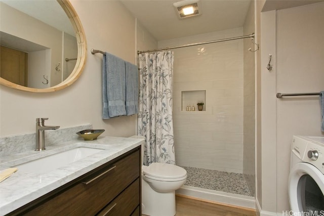 bathroom featuring toilet, vanity, curtained shower, hardwood / wood-style flooring, and washer / clothes dryer