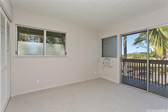 empty room featuring light colored carpet, a textured ceiling, and cooling unit