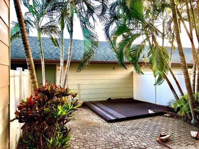 view of property exterior featuring a wooden deck and a patio