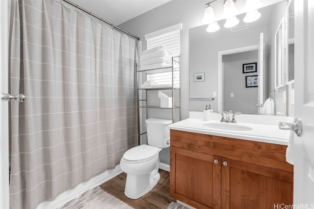 bathroom with hardwood / wood-style flooring, toilet, and vanity