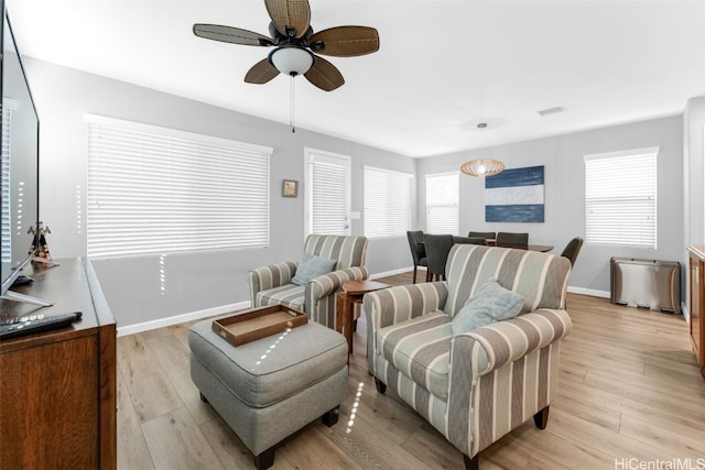 living room with ceiling fan and light hardwood / wood-style flooring