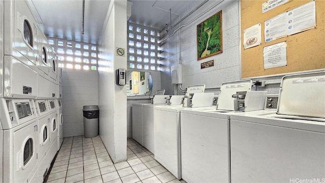 washroom with washer and dryer, stacked washing maching and dryer, and light tile patterned flooring