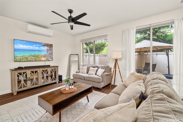 living room with a wall mounted air conditioner, hardwood / wood-style flooring, and ceiling fan