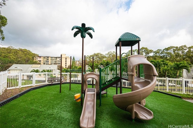 communal playground featuring fence and a lawn